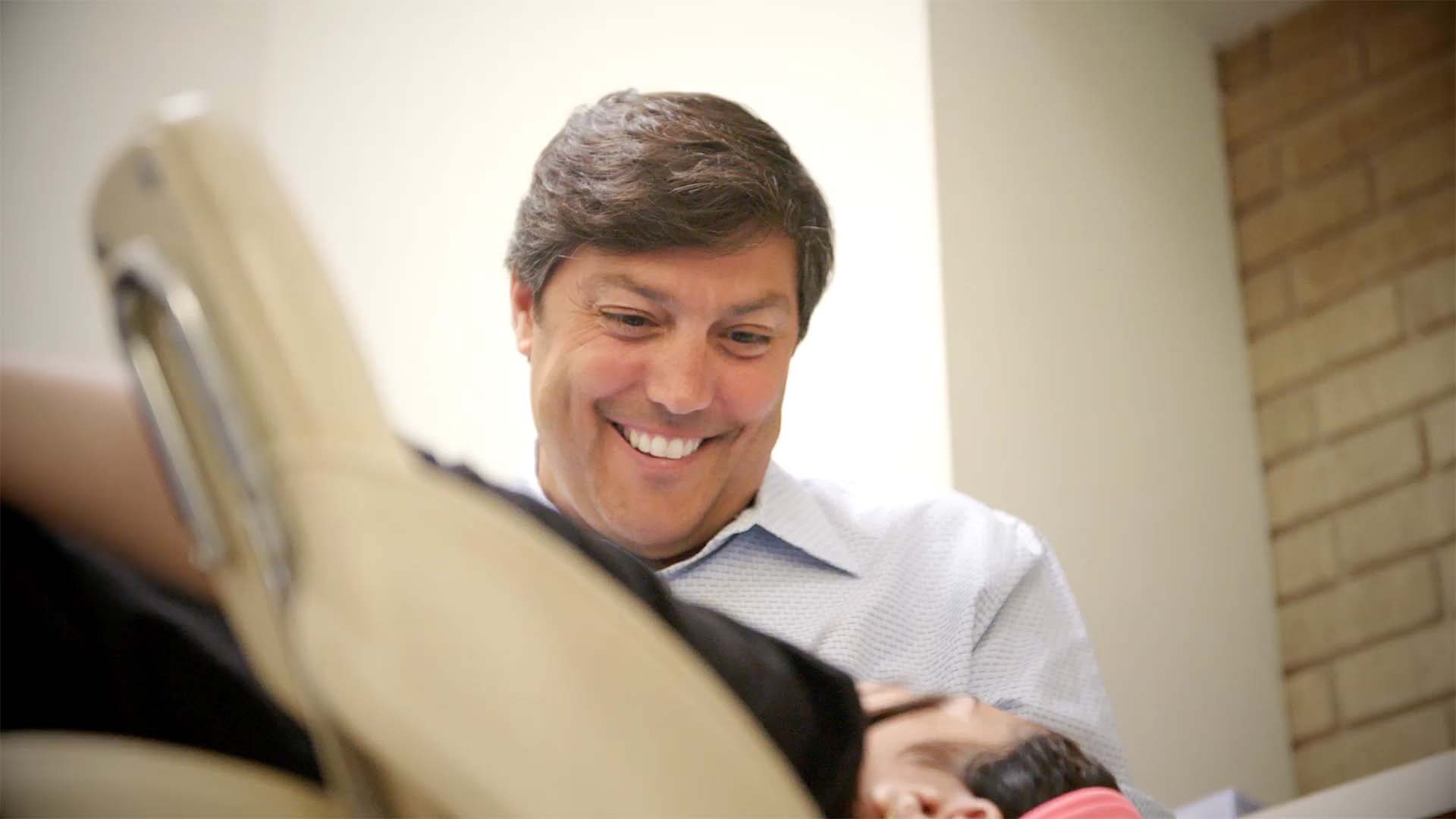 Dr Stefen Lippitz smiles while examining a patient from Kenilworth