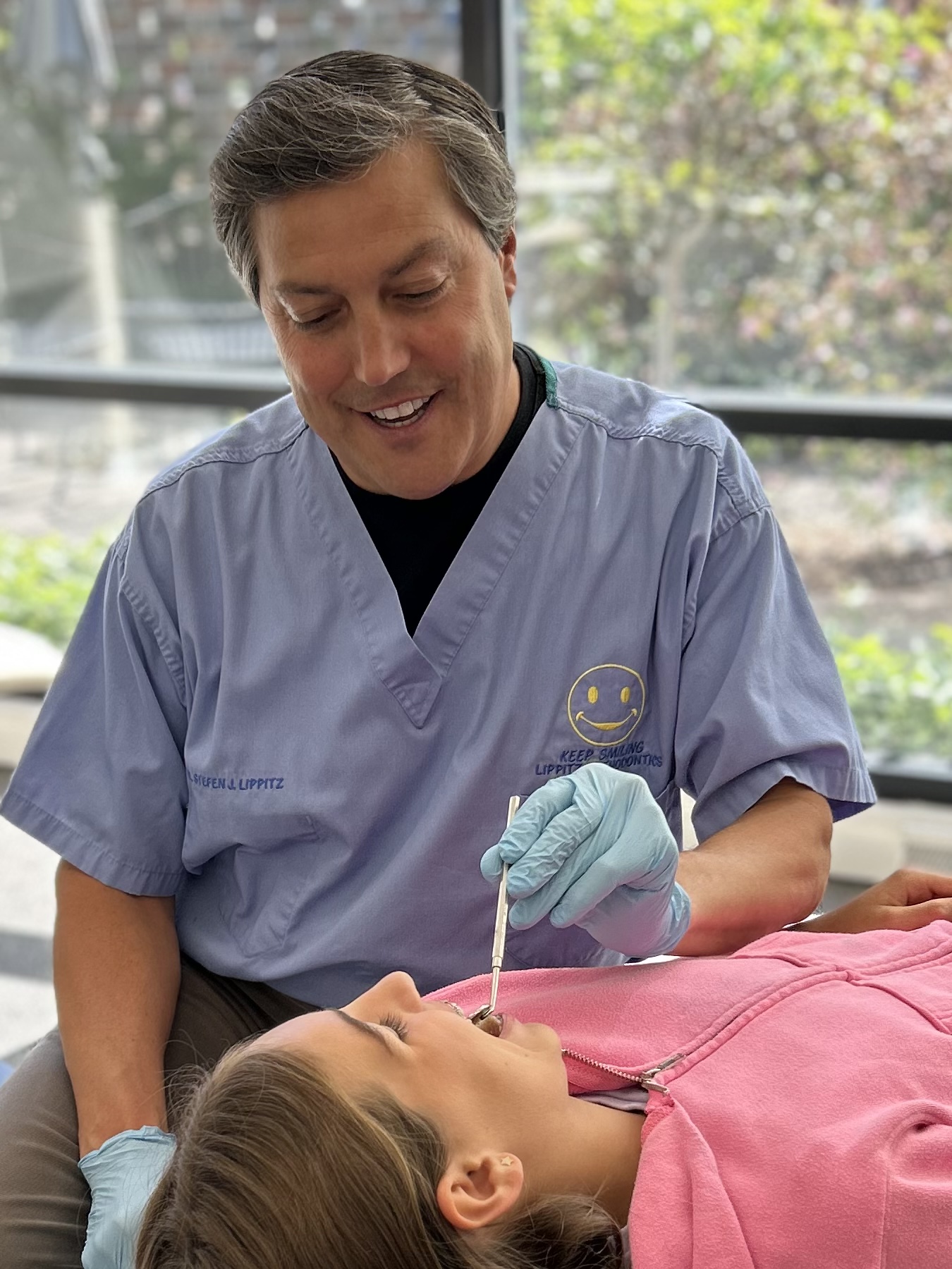 Smiling Dr. Lippitz examines a young patient