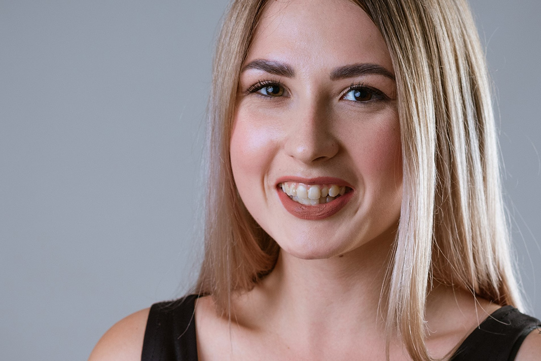 Blonde woman in Lincolnshire IL smiling with overcrowded teeth wanting to straighten them with Invisalign