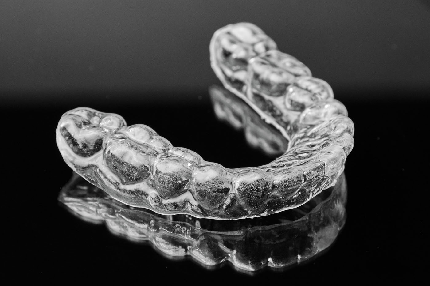 clear dental retainer on reflective table