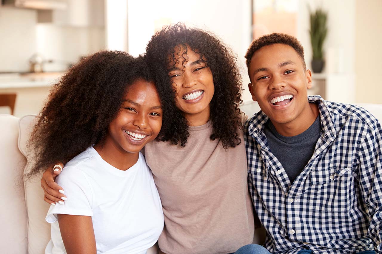 Happy teens with beautiful smiles, now wearing retainers after finishing their braces treatment.