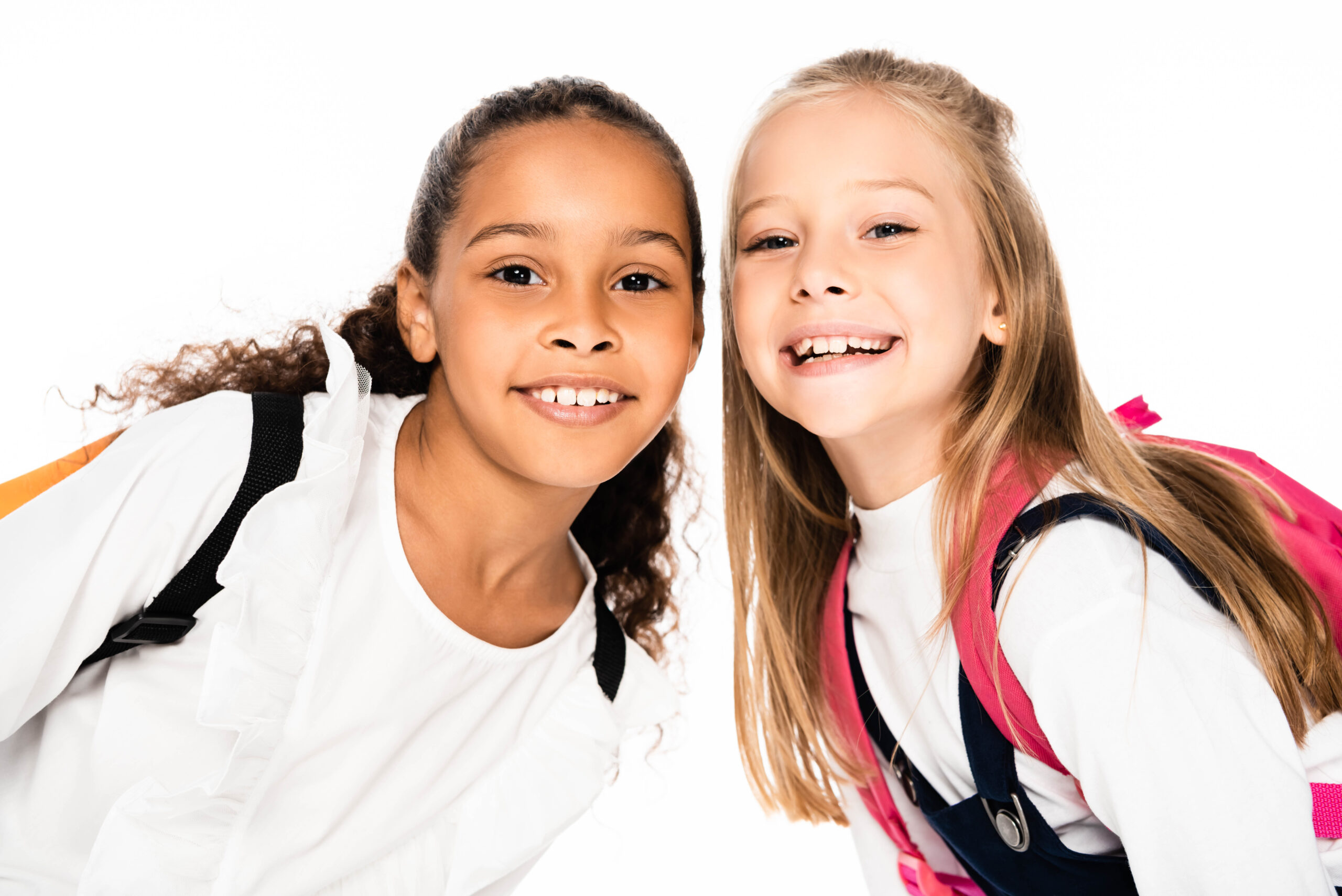 Happy schoolgirls looking at the camera, helping ease braces anxiety for young patients.