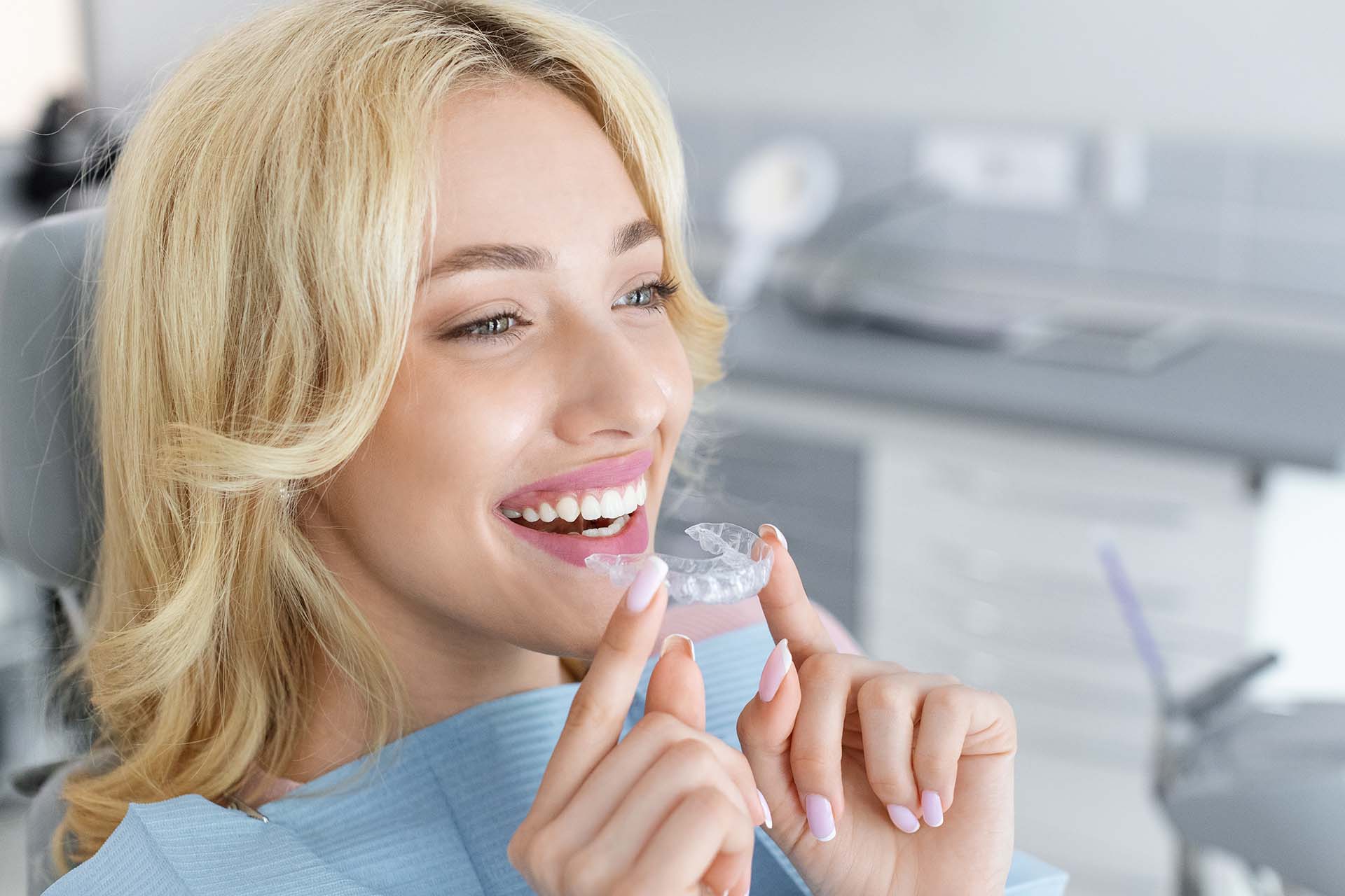 young woman holding her clear retainer